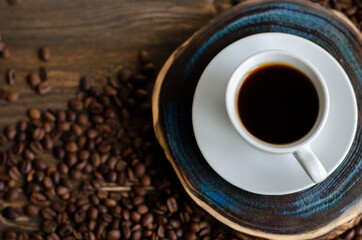 a cup of coffee with sprinkled coffee beans on the table