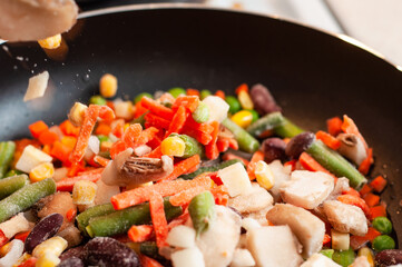 The process of filling frozen vegetables in a pan
