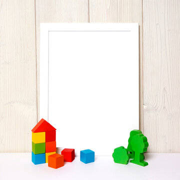 
Happy Father's Day concept mockup. White frame with photo space on a wooden background with a children's car and colored blocks. Picture frame mock up template for Father's day holiday.