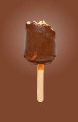 half eaten chocolate outer popsicle on brown background