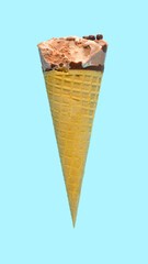 side view fresh chocolate flavor ice cream cone with a bite on a blue background