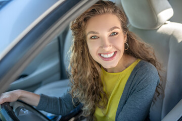 Fototapeta na wymiar Happy young smiling woman driving a car