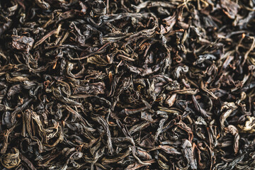 Black large-leaf tea as a background. Texture of dry black tea leaves.