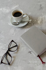 cup of coffee on the table with office items notebook, flashcard