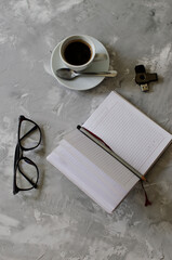 cup of coffee on the table with office items notebook, flashcard