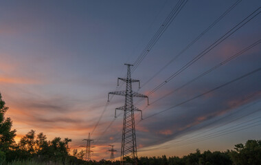 High-voltage power lines at sunset or sunrise. High voltage electric transmission tower
