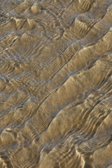 abstract effect of water movement on a sandy bottom with sunny reflections