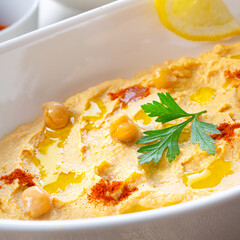 hummus paste with lemon and chilli on white background