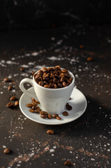 coffee beans in a small white cup. sprinkled coffee beans