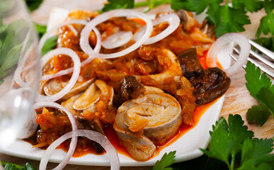 Marinated herring with mushrooms and tomato sauce on plate