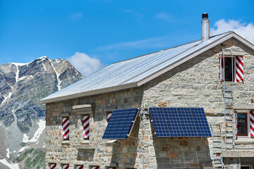 Horizontal snapshot of the alpine hut that is located in Pennine Alps, solar panels installed on...