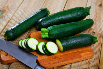 Image of cut raw green zucchini on wooden surface