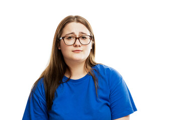 Fototapeta premium Young girl in glasses with a mournful face. Problems and helplessness. Isolated on a white background.