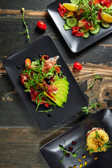 Plates with fresh vegetable salads on wood table