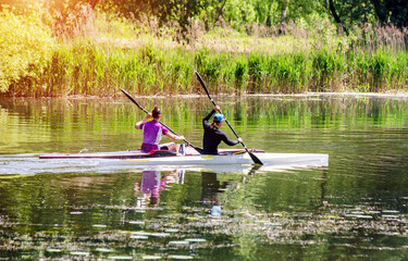 Two girls floating in a canoe on the river
