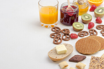 Cereal, cookies juice, fruit jam cookies, strawberries, kiwi, honey, orange juice. White background. Ingredients for breakfast