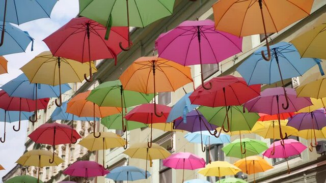 Colorful Umbrellas Hanging in the Air above the Street. Low angle view