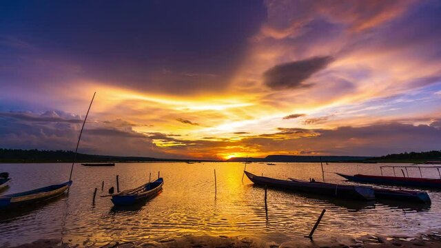 day to night timelapse of wooden boat at banks of the river with sunset in Khonburi, Nahon Ratchasima province, Thailand.