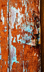 Peeling painted fence with rusted lock old
