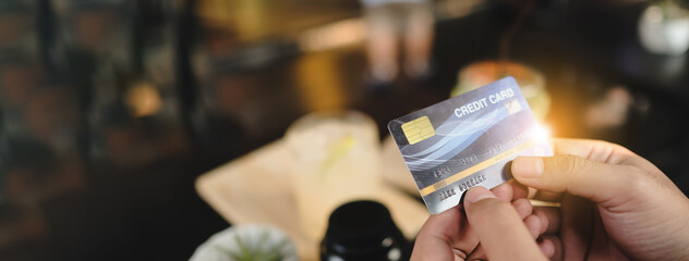 Mockup image of hand’s woman holding credit card with blank screen in cafe.-Banner