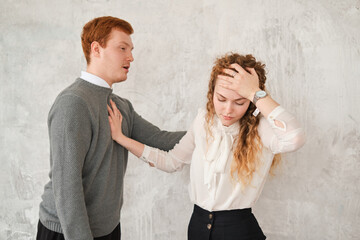 Unhappy young couple arguing, offended affronted woman pushing man staying her back, wife has...