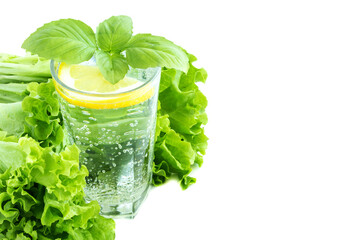 Glass of water with lemon, lettuce and tape measure. Drinking water and lettuce isolated on a white background. The concept of healthy eating and nutrition for weight loss. Copy space.