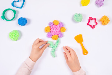 Early development concept. Hands play with modeling clay and making flower