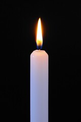 White candle against a black background.