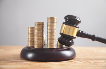 Stack of coins with judge gavel.