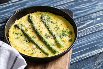 Asparagus with scrambled eggs. Omelet with asparagus  in a frying pan.