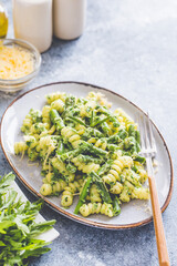 pasta with green vegetables and creamy sauce. fusilli pasta with asparagus beans and spinach on...