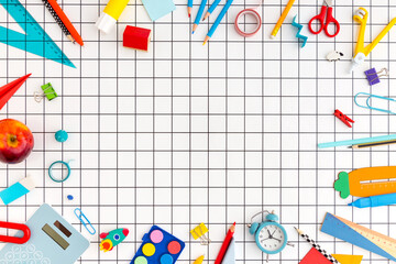 School supplies on a grid background. Back to school creative and abstract flat lay with copy space.