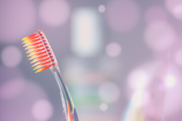 Orange plastic toothbrush on a purple background with round bubbles