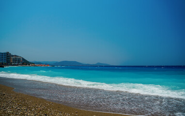 Peaceful sea wave foams on the beach, Aegean Sea, Rhodes, Greece.