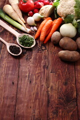 Fresh vegetables and spices on a wooden table.