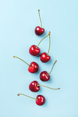 Obraz na płótnie Canvas Composition of ripe cherries on a blue background. Flat lay, top view.