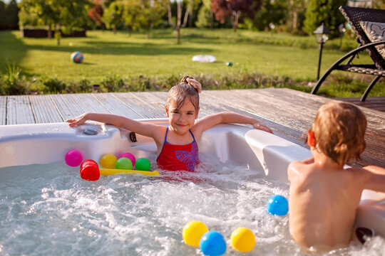 Staycation in summer cottage. Kid having rest in bathtub with bubby water, happy summertime