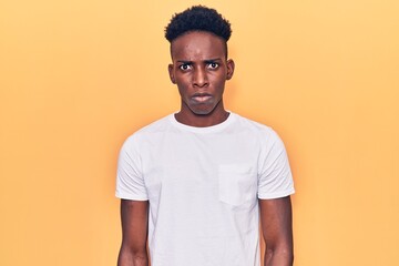 Young african american man wearing casual clothes skeptic and nervous, frowning upset because of...