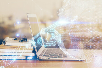 Computer on desktop in office with technology theme hologram. Multi exposure. Tech concept.