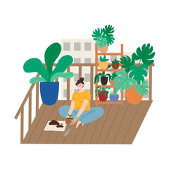 Smiling woman sitting on balcony and replanting plant in pot