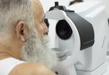 Senior patient checking vision with special eye equipment