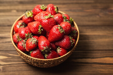 Ripe organic strawberries in a wooden basket on a table