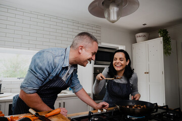 Couple having fun, laughing in the kitchen and cooking together