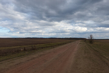 A dirt road among the fields in the evening. Autumn landscape.