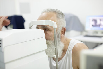 Senior patient checking vision with special eye equipment