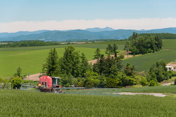 北海道の広大な畑で農薬散布する