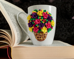 The original mug with decorative figurines made with their own hands. A lovely birthday present. Figures on the cup are fashioned hand made from colored clay. Stands on the book. High quality photo