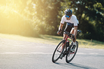Cyclist pedaling on a racing bike outdoors in sun set .The image of cyclist in motion on the...