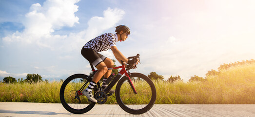 Cyclist pedaling on a racing bike outdoors in sun set .The image of cyclist in motion on the...