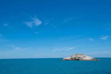 Small island on the blue sky background